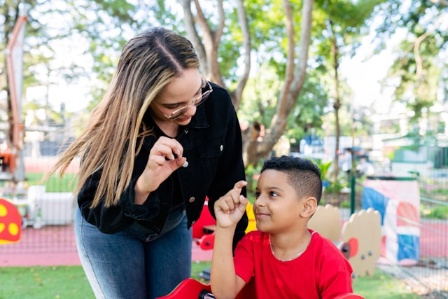 Adult playing with an autistic child outdoors